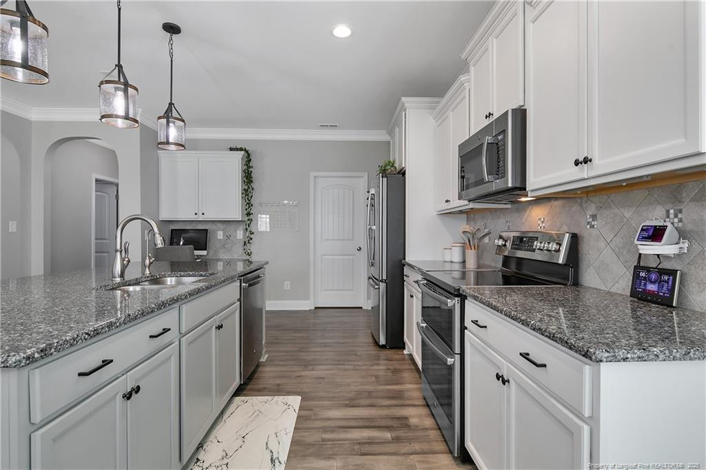 2628 Riddle Farm Road Fayetteville, NC 28306 - Photo 22 of 50 a kitchen with stainless steel appliances granite countertop a sink stove oven and refrigerator