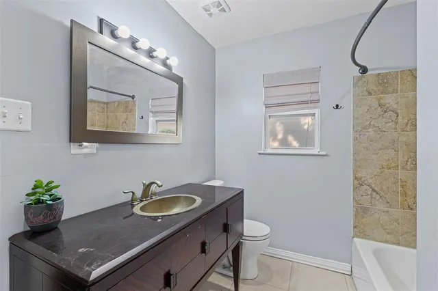 a bathroom with a granite countertop sink a mirror and a toilet