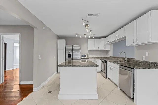 a kitchen with stainless steel appliances granite countertop a sink and a stove