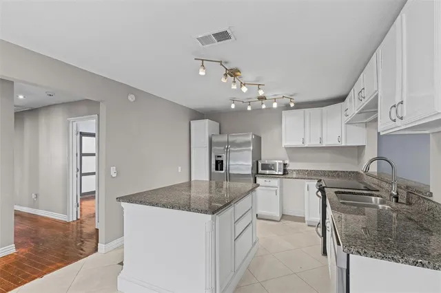 a kitchen with stainless steel appliances granite countertop a sink dishwasher and refrigerator