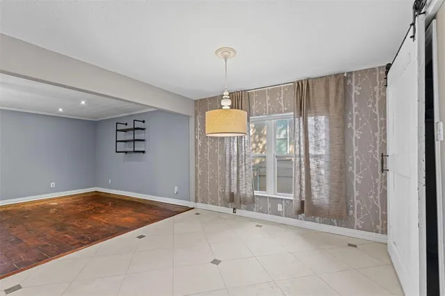 a view of a room with a chandelier fan and kitchen view