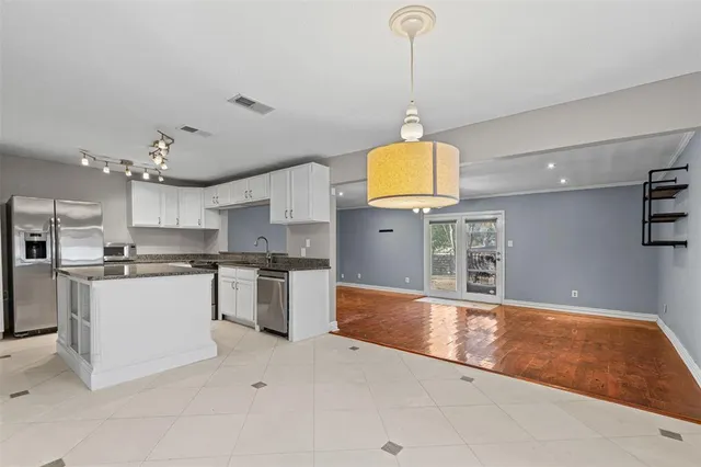 a backyard of a house with table and chairs and potted plants