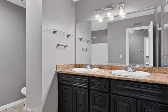 a bathroom with a granite countertop sink a large mirror and a light fixture