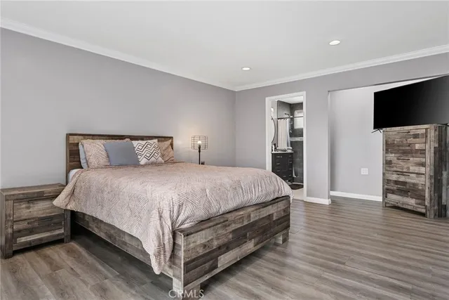 a spacious bedroom with a bed and a flat screen tv