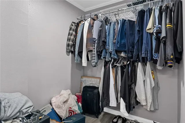 a view of walk in closet with clothes and shoes