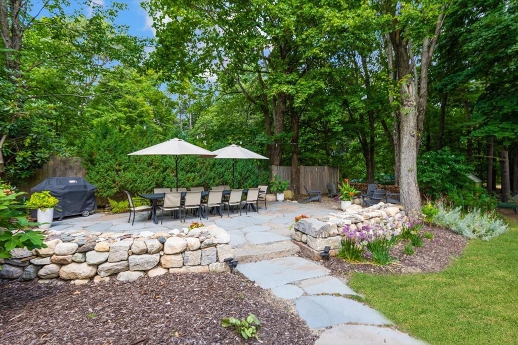 150 High Street Norwell, MA 02061 - Photo 3 of 39 a backyard of a house with table and chairs under an umbrella