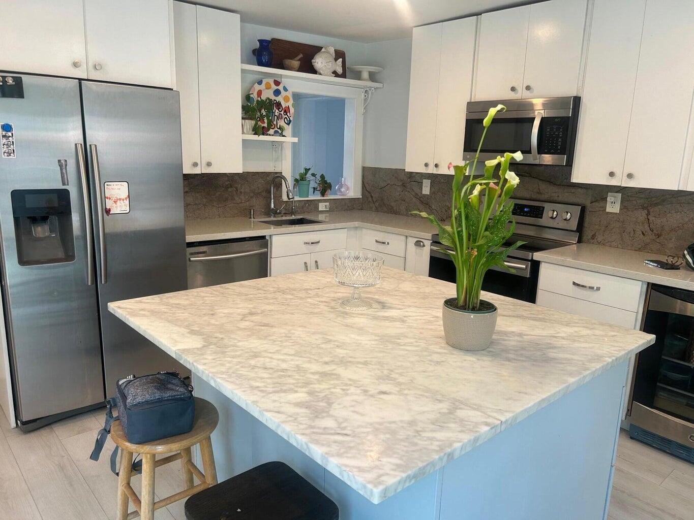 820 30th Street West Palm Beach, FL 33407 - Photo 11 of 40 a kitchen with kitchen island granite countertop a sink a counter and stainless steel appliances