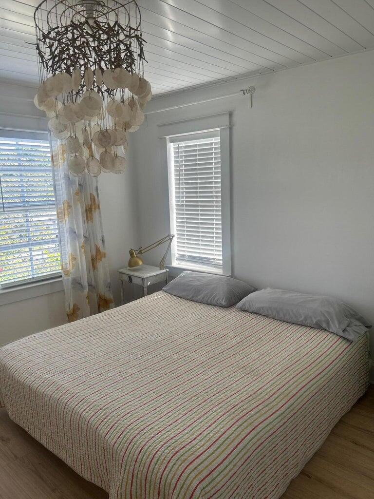 820 30th Street West Palm Beach, FL 33407 - Photo 19 of 40 a bedroom with a large bed and a chandelier