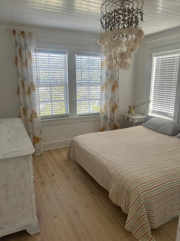820 30th Street West Palm Beach, FL 33407 - Photo 23 of 40 a bedroom with a bed and a chandelier