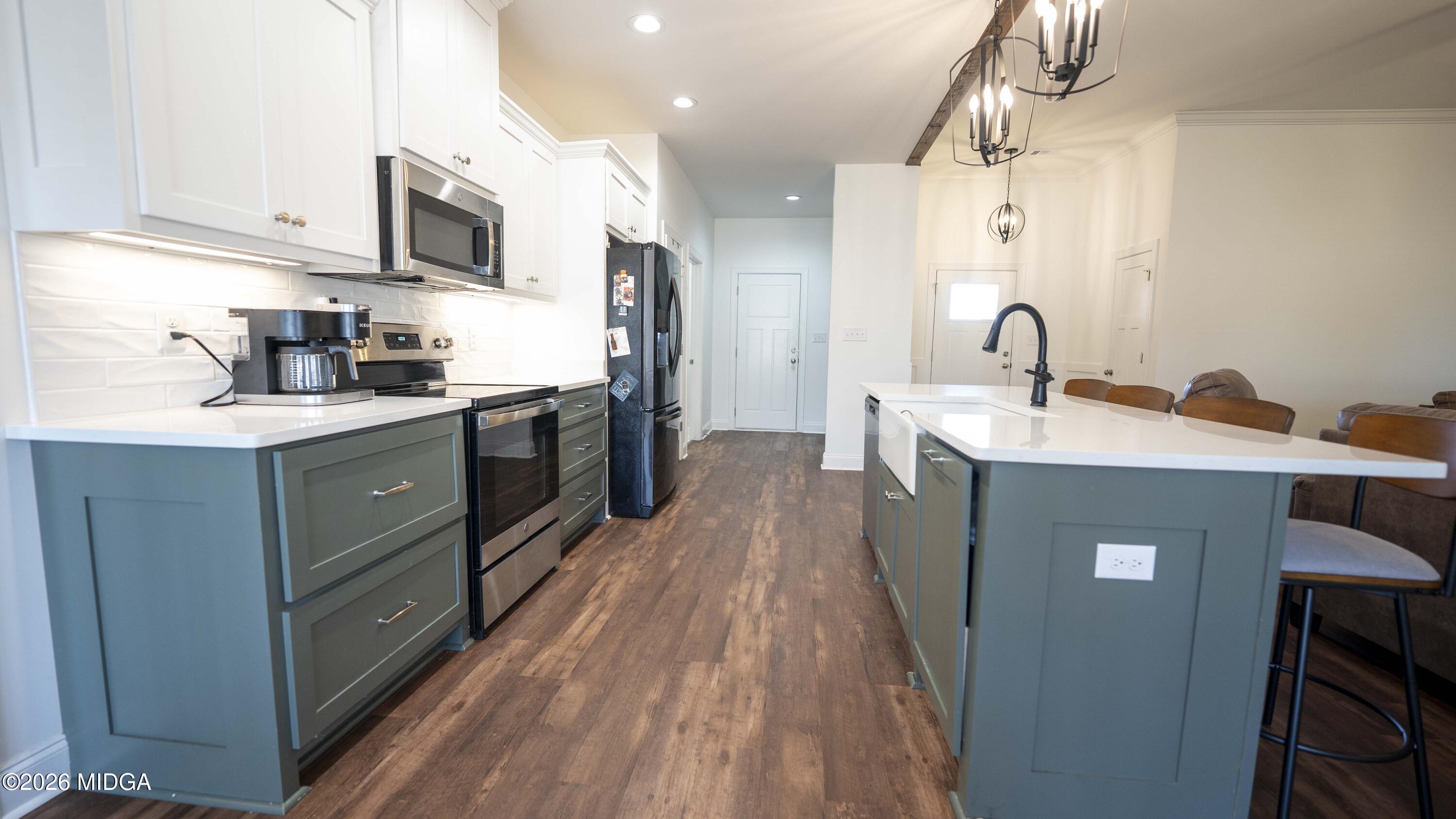 106 Raspberry Trail Perry, GA 31069 - Photo 14 of 42 a kitchen with stainless steel appliances a sink dishwasher a stove top oven a refrigerator with wooden floor and cabinets