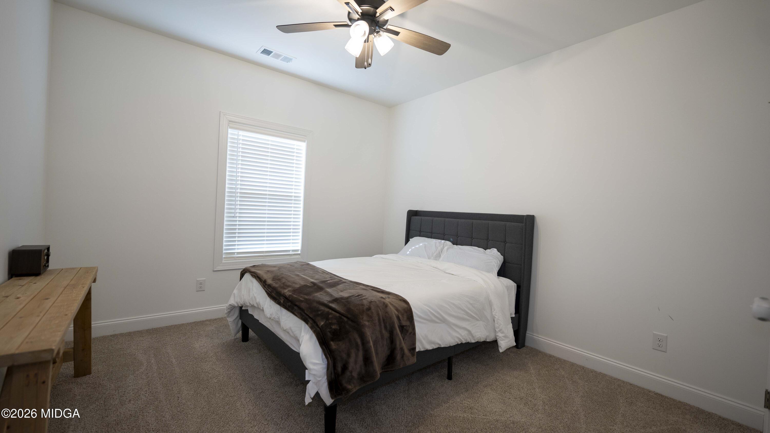 106 Raspberry Trail Perry, GA 31069 - Photo 35 of 42 a bedroom with a bed and a chandelier