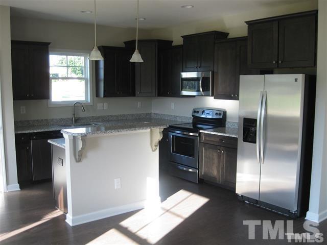 10894 Selma Road Middlesex, NC 27557 - Photo 4 of 12 a kitchen with granite countertop a refrigerator and a stove top oven