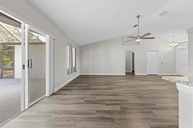 a view of empty room with wooden floor and ceiling fan