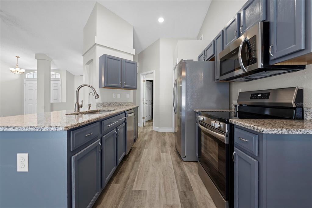 8155 Giffen Lane Spring Hill, FL 34608 - Photo 16 of 52 a kitchen with stainless steel appliances granite countertop a refrigerator a stove and a sink