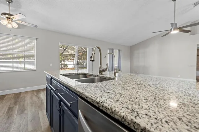 a kitchen with a sink and wooden floor
