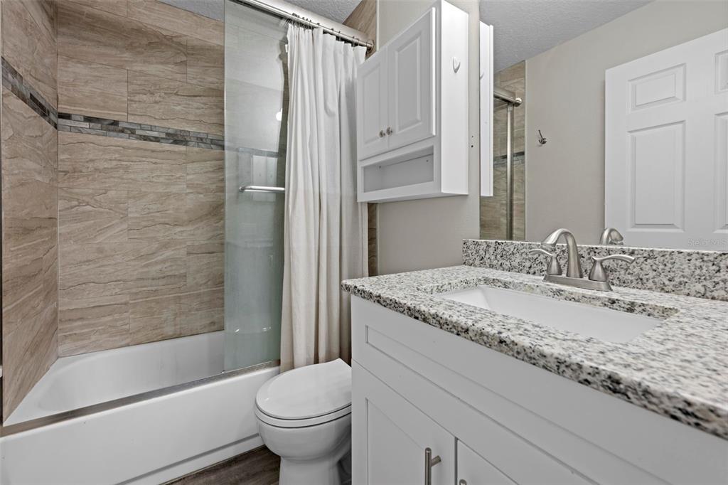 8155 Giffen Lane Spring Hill, FL 34608 - Photo 21 of 52 a bathroom with a granite countertop sink toilet and shower