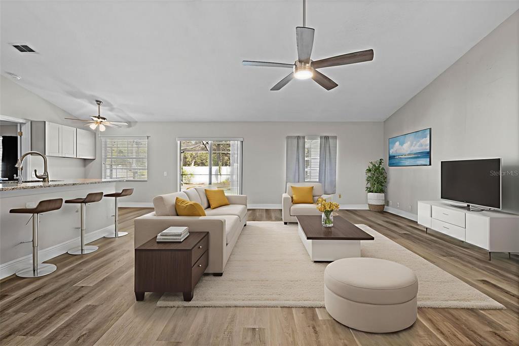 8155 Giffen Lane Spring Hill, FL 34608 - Photo 3 of 52 a living room with furniture a flat screen tv and kitchen view