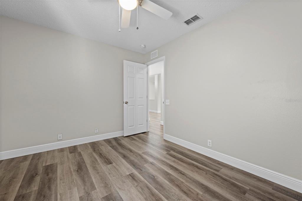 8155 Giffen Lane Spring Hill, FL 34608 - Photo 32 of 52 an empty room with wooden floor and windows