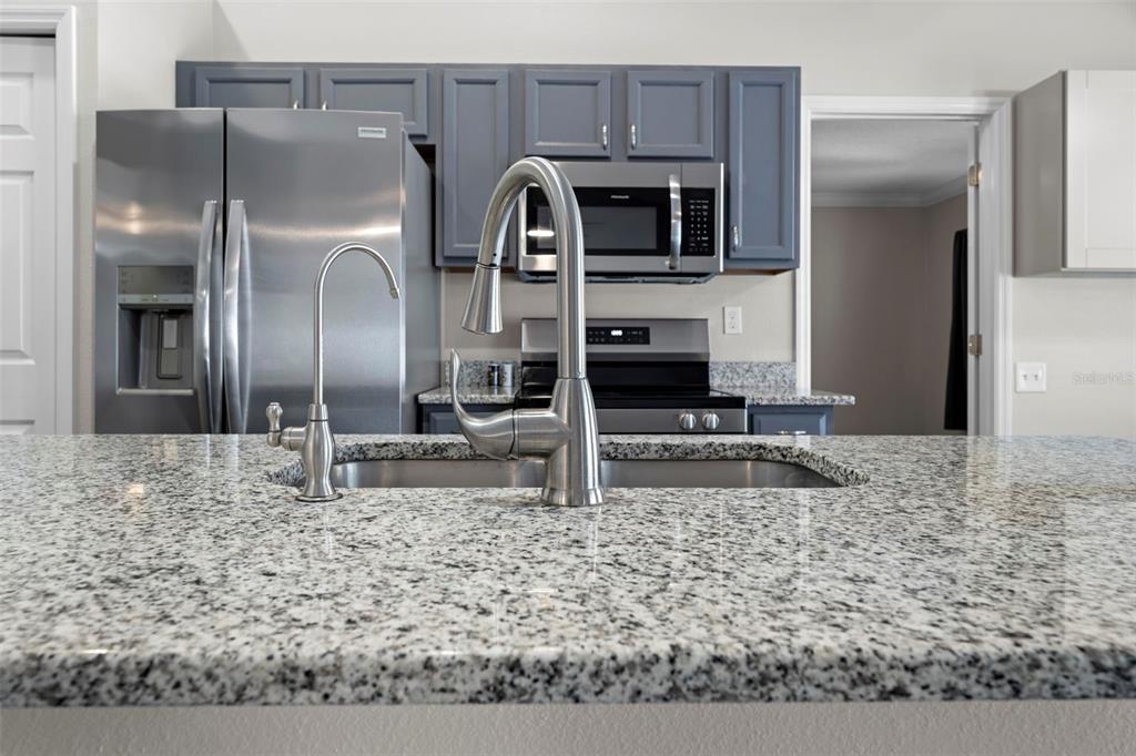 8155 Giffen Lane Spring Hill, FL 34608 - Photo 4 of 52 a kitchen with granite countertop a refrigerator and a stove top oven