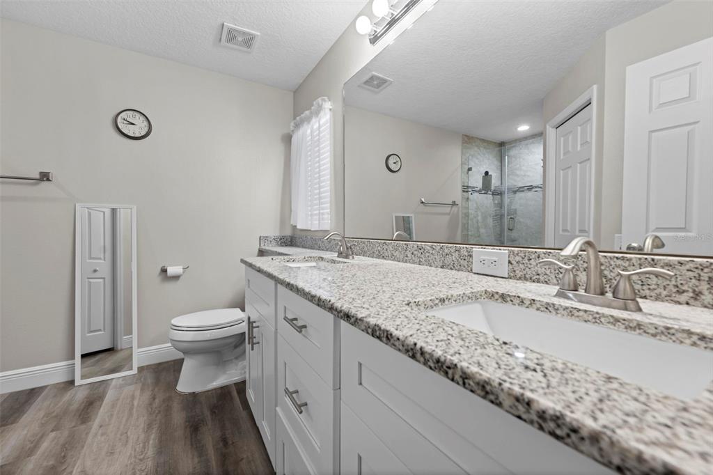 8155 Giffen Lane Spring Hill, FL 34608 - Photo 5 of 52 a bathroom with a granite countertop sink a toilet and a mirror