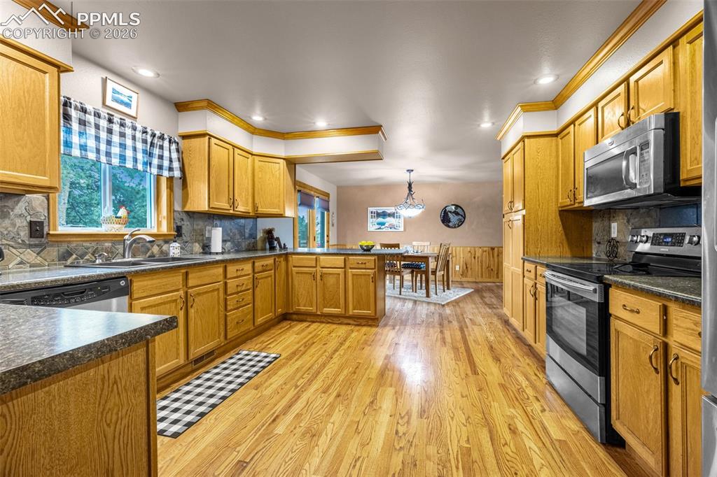 143 Ring Road Guffey, CO 80820 - Photo 6 of 36 Large kitchen featuring stainless steel appliances, a peninsula/bar for casual dining and hardwood flooring