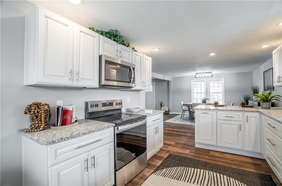 8240 Looney Road Piqua, OH 45356 - Photo 14 of 49 This modern kitchen features crisp white cabinetry and sleek stainless steel appliances, perfect for culinary adventures.