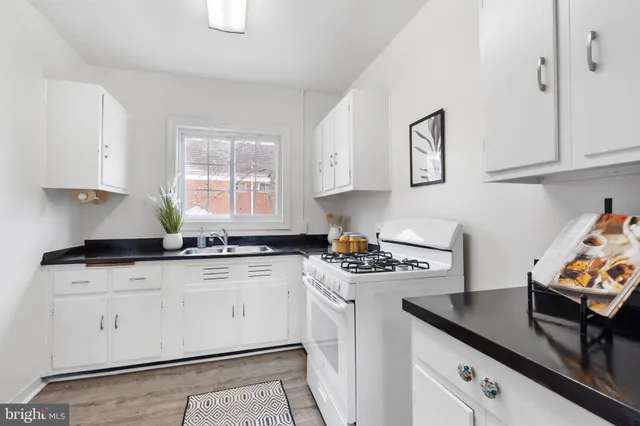 a kitchen with stainless steel appliances granite countertop a sink stove and cabinets