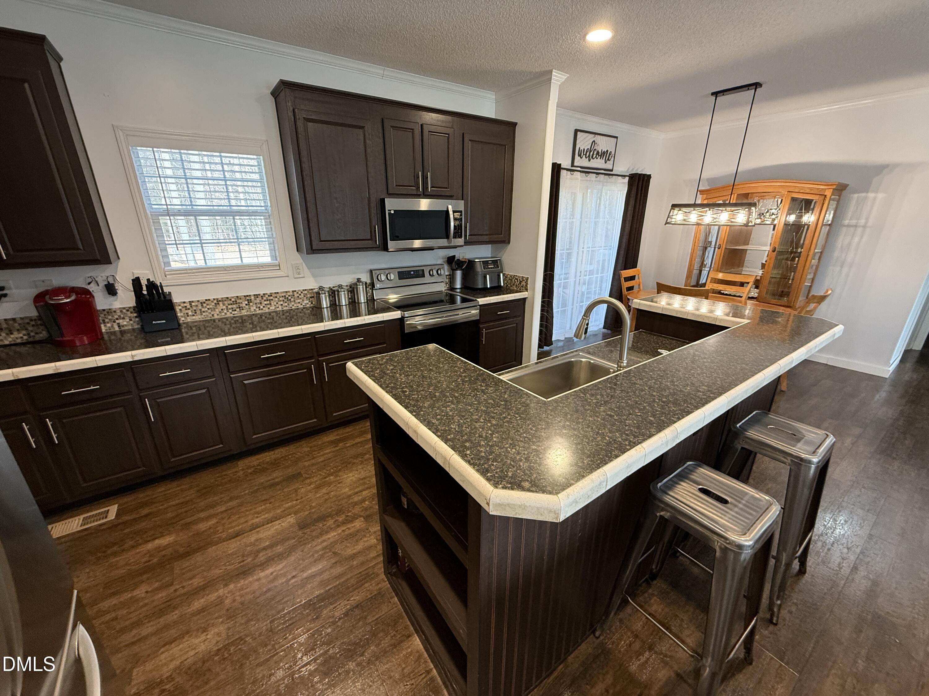 11242 Bissette Road Middlesex, NC 27557 - Photo 12 of 49 a kitchen with a stove a sink dishwasher a refrigerator and a microwave
