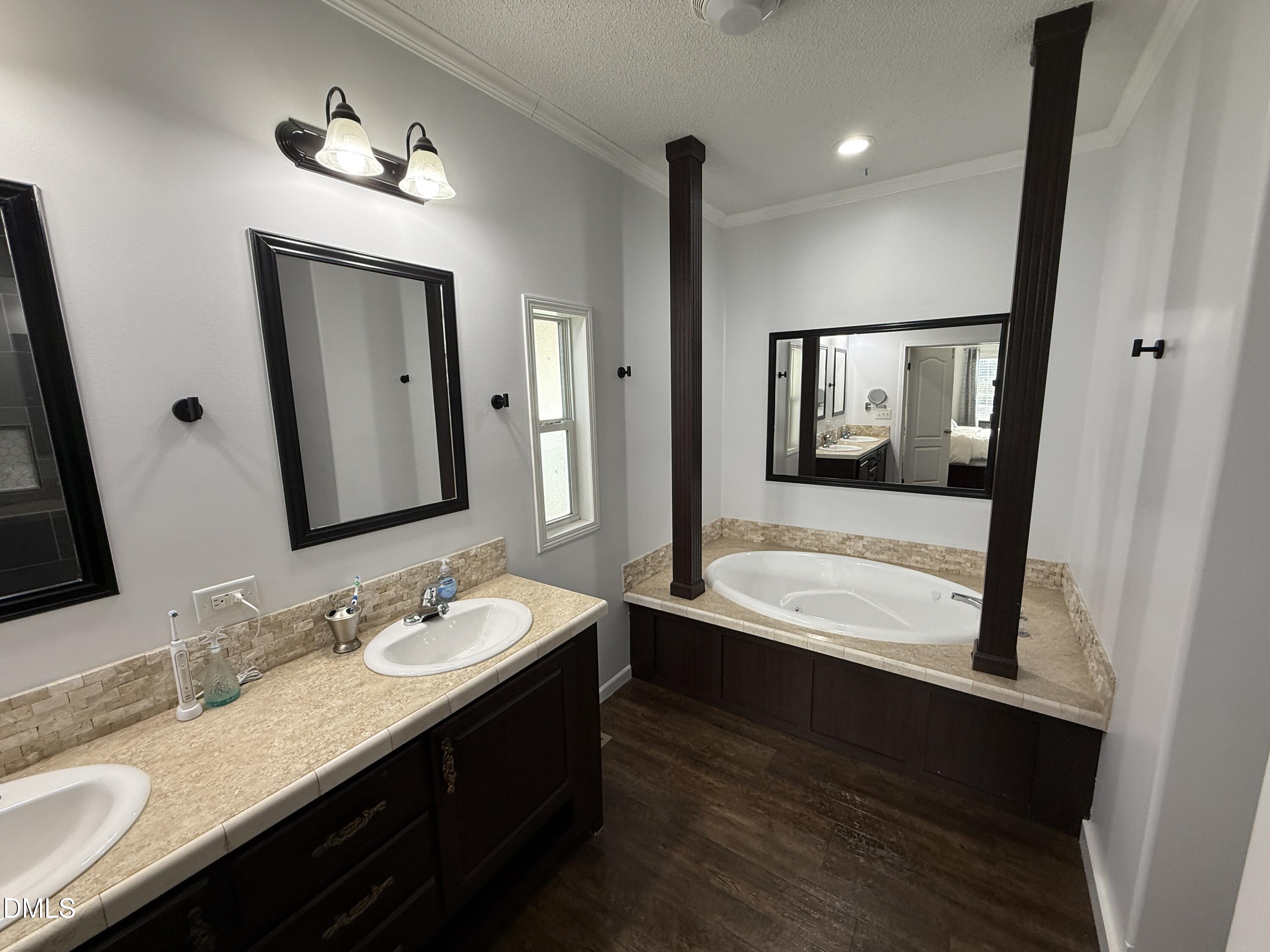 11242 Bissette Road Middlesex, NC 27557 - Photo 18 of 49 a bathroom with a granite countertop sink a mirror and a bathtub