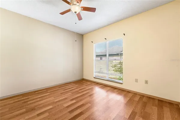 a view of a room with wooden floor and a ceiling fan