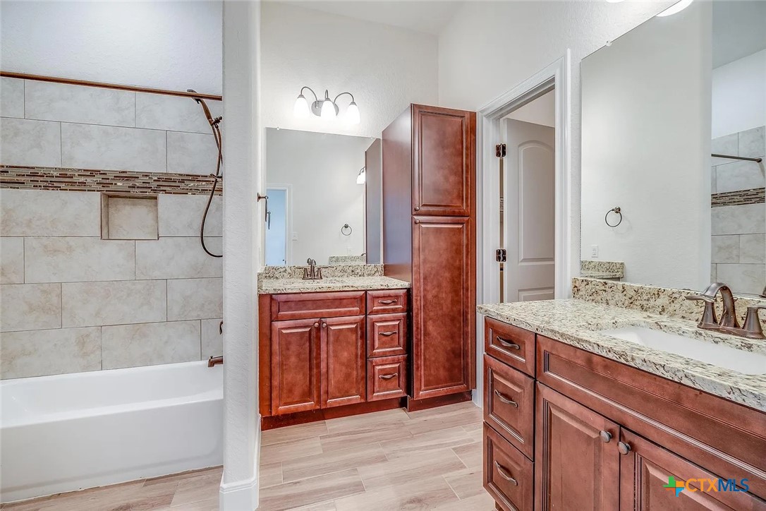 3133 Puter Creek Road, Unit B Spring Branch, TX 78070 - Photo 13 of 19 a bathroom with a granite countertop sink a toilet and shower