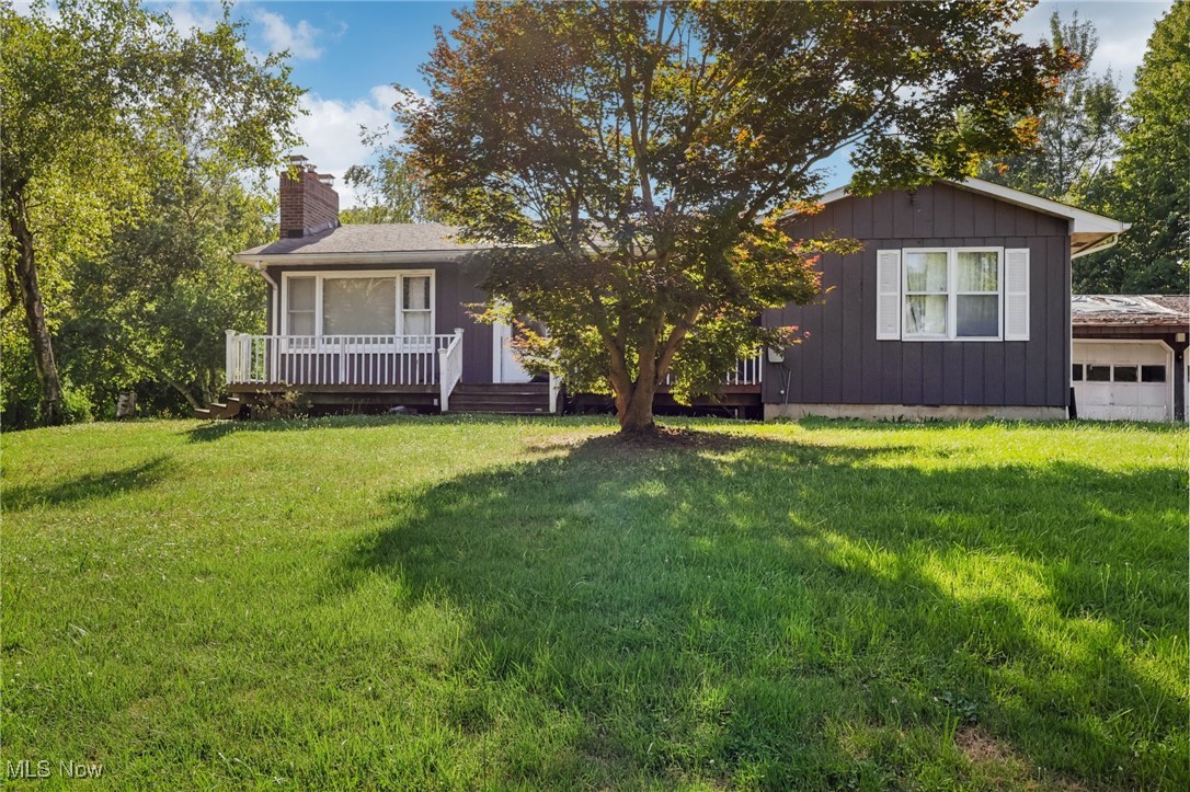 2916 Sexton Road Geneva, OH 44041 - Photo 1 of 23 Ranch-style home with a garage, a chimney, a front yard, a deck, and board and batten siding