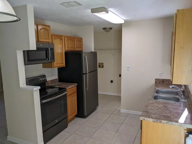a kitchen with stainless steel appliances granite countertop a refrigerator and a stove