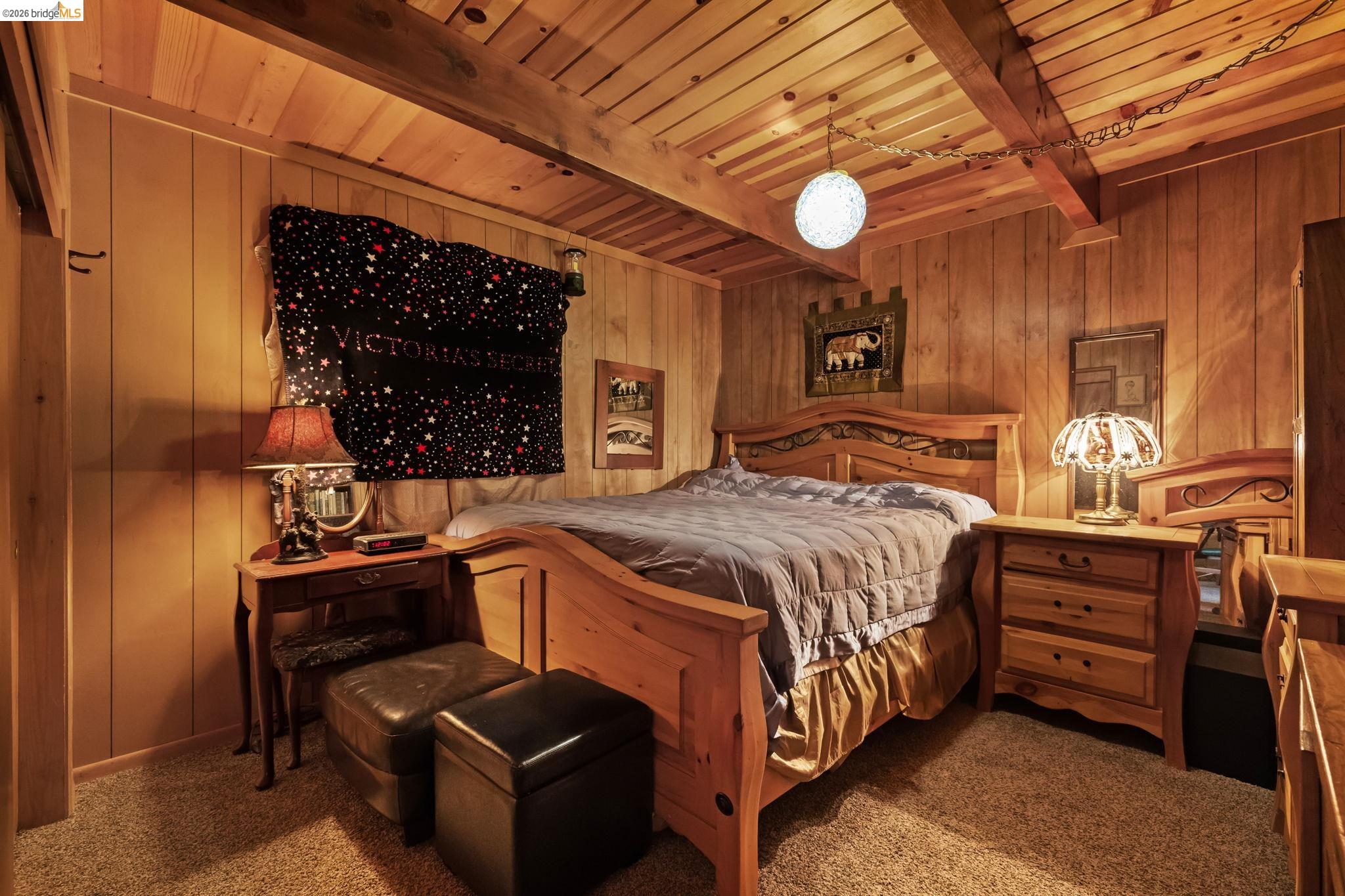 26039 Long Barn Road Long Barn, CA 95335 - Photo 15 of 27 Carpeted bedroom featuring wooden walls and a wooden ceiling with exposed beams