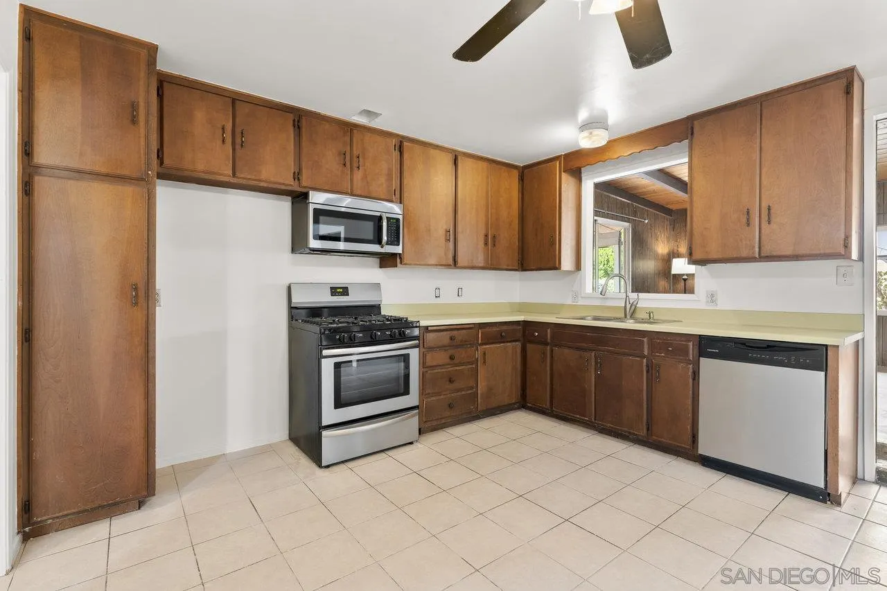 582 Macon Street El Cajon, CA 92019 - Photo 13 of 34 a kitchen with granite countertop a refrigerator and a sink