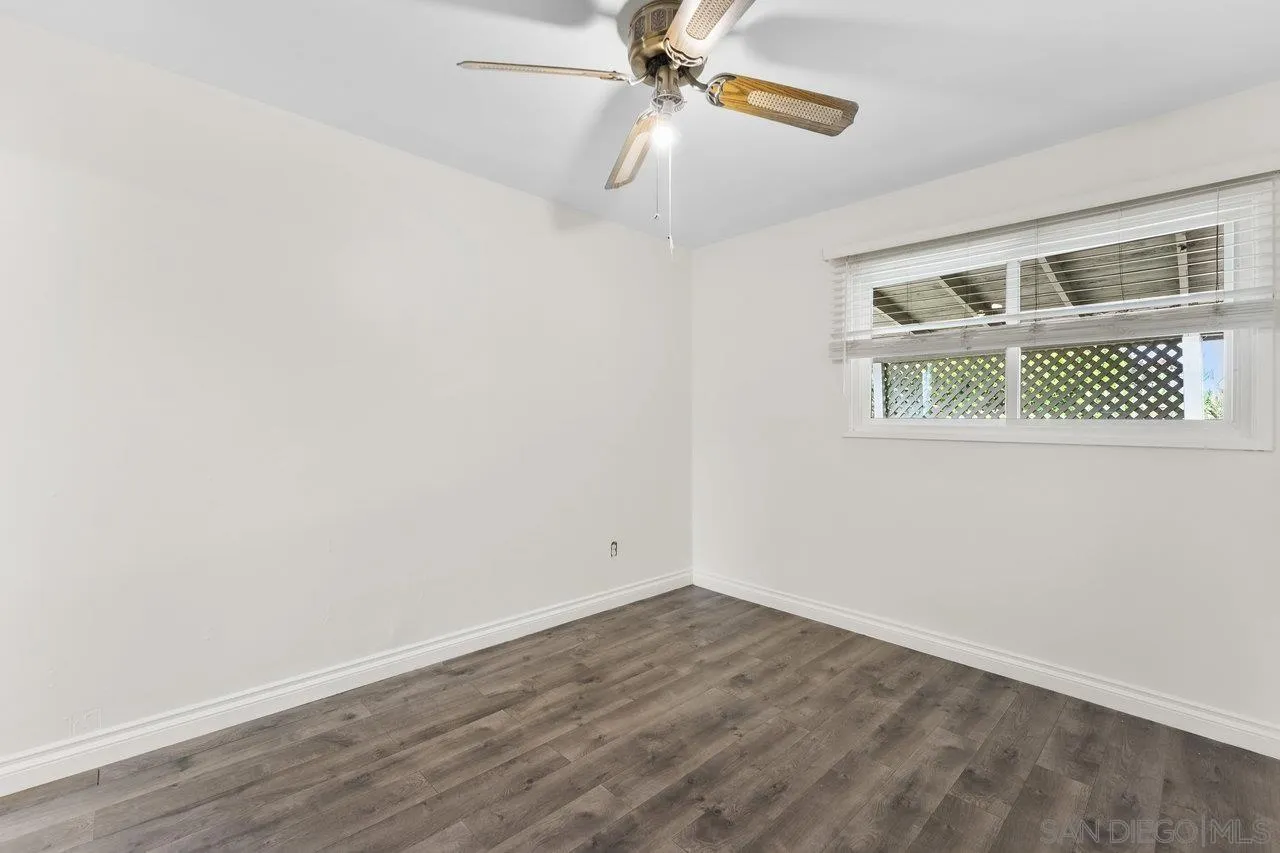 582 Macon Street El Cajon, CA 92019 - Photo 16 of 34 an empty room with wooden floor ceiling fan and windows