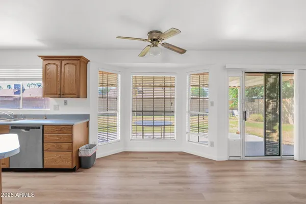 a view of an empty room with window and wooden floor