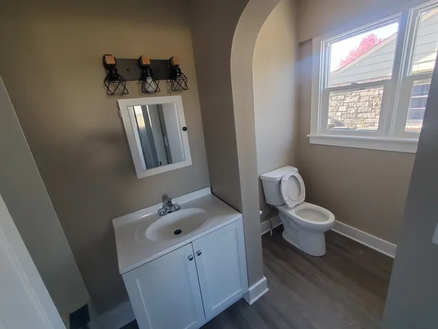 a bathroom with a toilet sink and mirror