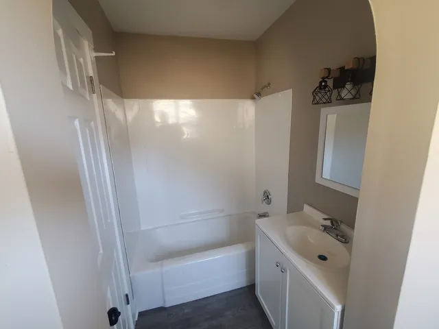a bathroom with a tub sink and mirror