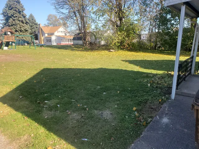 a view of yard with swimming pool and trees in the background