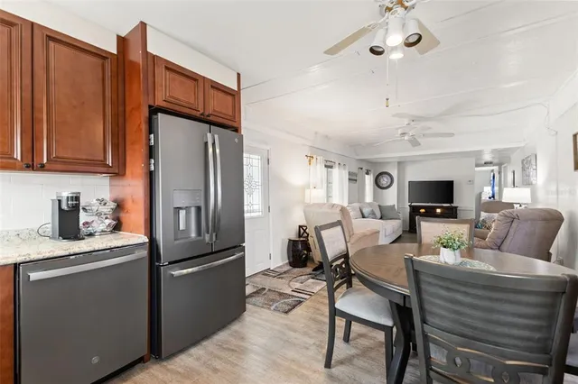a living room with stainless steel appliances kitchen island granite countertop furniture and a refrigerator