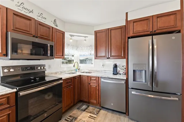 a kitchen with stainless steel appliances granite countertop a refrigerator stove microwave and sink