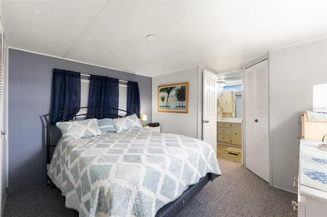 a large bed sitting in a bedroom and a table in closet