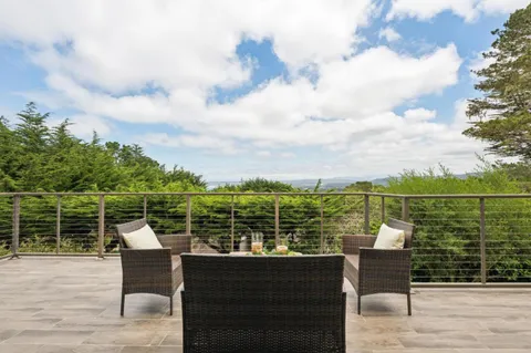a roof deck with table and chairs and wooden floor