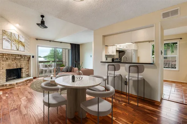a dining room with furniture a fireplace and wooden floor