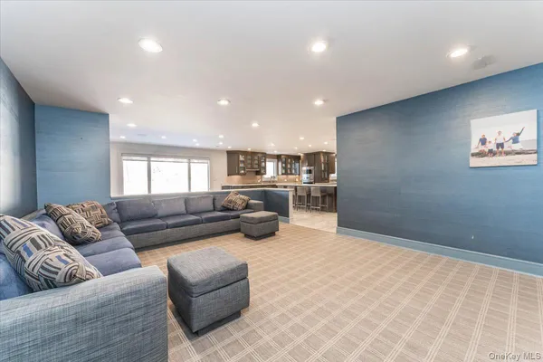 a living room with furniture and view of kitchen