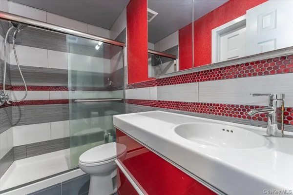 a bathroom with a sink a toilet and shower