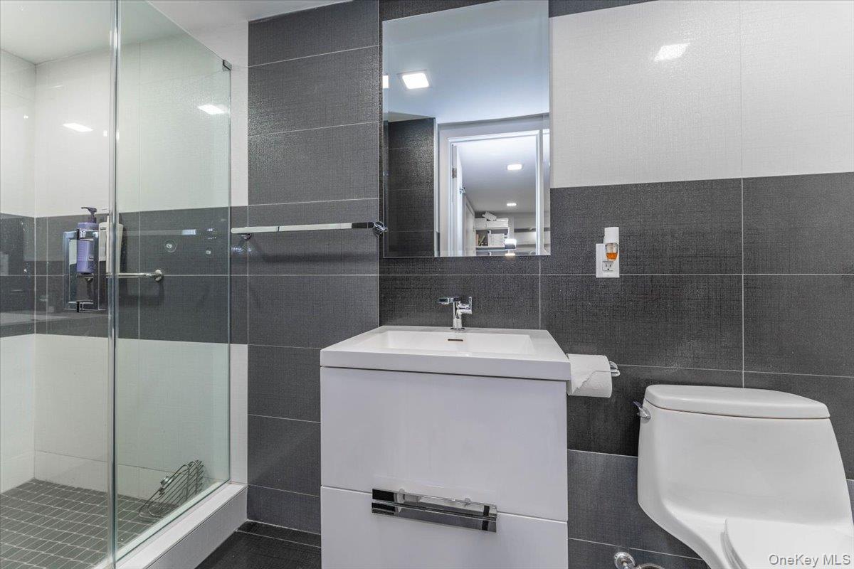 22 Larch Hill Road Lawrence, NY 11559 - Photo 26 of 31 a bathroom with a sink a toilet and a mirror