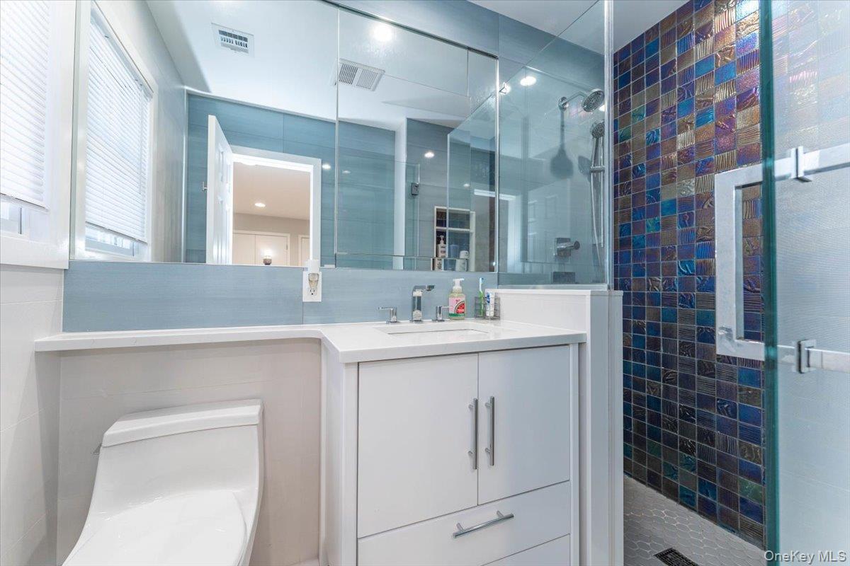 22 Larch Hill Road Lawrence, NY 11559 - Photo 27 of 31 a bathroom with a sink vanity and a mirror