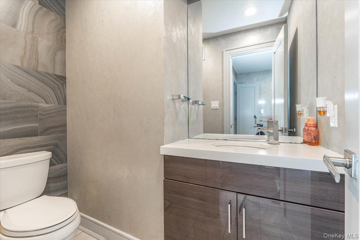 22 Larch Hill Road Lawrence, NY 11559 - Photo 29 of 31 a bathroom with a sink a toilet a mirror and vanity